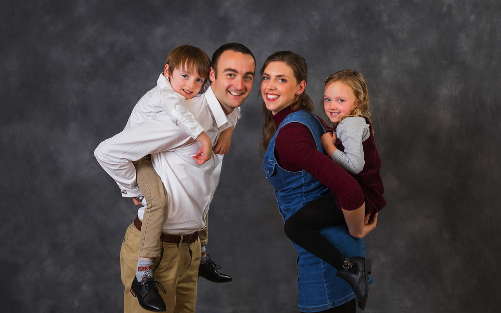 Happy Family, Poses On A Chair In An Interior Of Studio, A Strong  Close-knit Family Stock Photo, Picture and Royalty Free Image. Image  68412474.